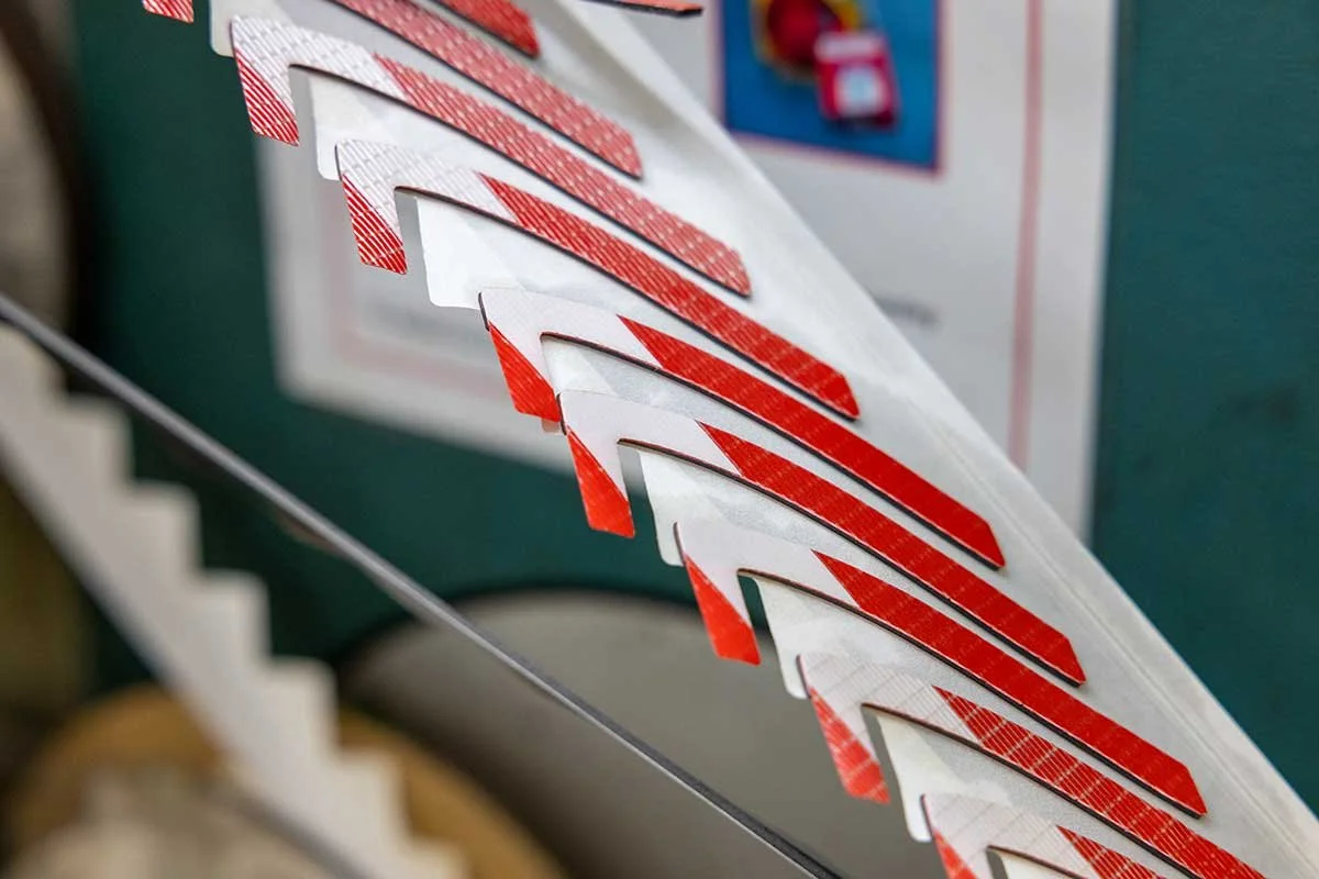 Close-up view of Christmas-themed string lights with red and white striped candy cane shapes, hanging in a zigzag pattern.
